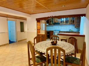 a dining room with a table and chairs and a kitchen at Los Horneros in Santa María