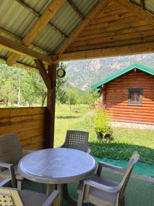 a patio with a table and chairs and a cabin at EtnoPetra in Mojkovac