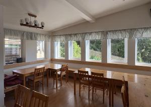 a dining room with wooden tables and chairs and windows at Chalupa Lázeňka in Pernink