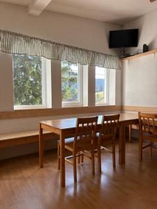 a dining room with a table and chairs and two windows at Chalupa Lázeňka in Pernink +45 photos