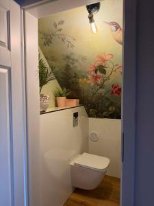 a bathroom with a toilet and a painting on the wall at Karkonosze pod gwiazdami in Jarkowice +19 photos