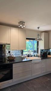 a large kitchen with white cabinets and a sink at Karkonosze pod gwiazdami in Jarkowice