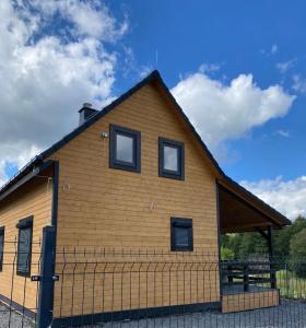 a large wooden building with windows on top at Karkonosze pod gwiazdami in Jarkowice