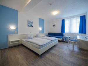 a bedroom with a large bed and a blue couch at Hotel Holländischer Hof in Lich