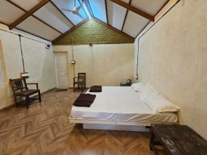 a bedroom with a bed and a table and chairs at K Bhoomi Joy by Earth in Bhīra Camp