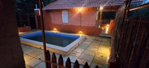 a swimming pool in front of a house at night at K Bhoomi Joy by Earth in Bhīra Camp
