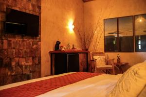 a bedroom with a bed and a tv on the wall at Hotel Pousada Rancho das Dunas in Santo Amaro