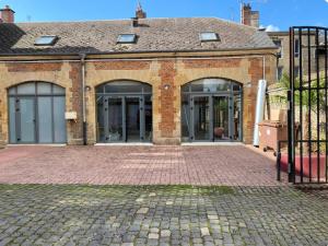 a brick building with doors and a brick driveway at La Cantina in Charleville-Mézières