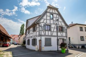 a white and black house with a turret at Le Bartholdi in Andolsheim