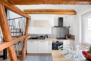 a kitchen with white cabinets and a table and chairs at Le Bartholdi in Andolsheim