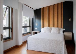 a bedroom with a white bed and two windows at O IGREXARIO Vacacional in Cangas de Morrazo +31 photos