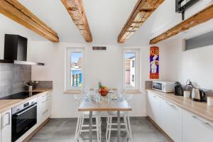 a kitchen with white cabinets and a table with chairs at Le Bartholdi in Andolsheim