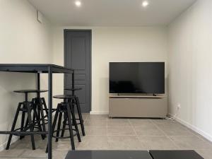 a living room with a flat screen tv and bar stools at Appartement tout confort à Auriol in Auriol