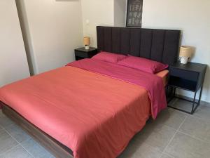 a bedroom with a large red bed with two night stands at Appartement tout confort à Auriol in Auriol +4 photos