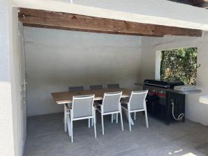 a patio with a table and chairs and a grill at Appartement tout confort à Auriol in Auriol