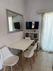 a white dining room table with chairs and a mirror at Moderna Yaya - Andros Chora in Andros