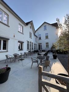a patio with tables and chairs next to a building at La Villa Blanche Spa in Spa