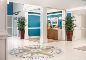 a lobby with blue walls and potted plants at Compass by Margaritaville Beaufort in Beaufort +26 photos