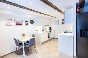 a kitchen with white cabinets and a table and chairs at CPH Guest Homes in Copenhagen