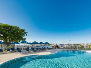 a swimming pool with lounge chairs and a marina at Compass by Margaritaville Beaufort in Beaufort