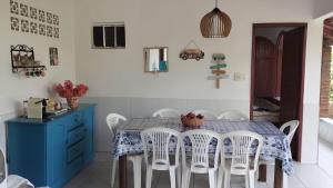 a dining room with a blue table and white chairs at Casa Luna in Marau