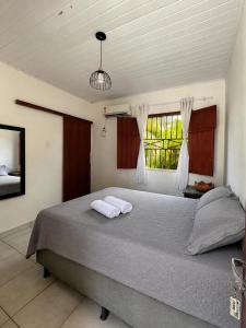 a bedroom with a bed with two towels on it at Casa Luna in Marau