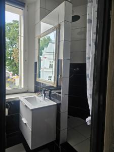 a bathroom with a sink and a window at Apartament DARIS in Wałbrzych +10 photos