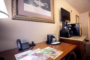 a desk in a hotel room with a phone on it at The O'Brien Riverwalk Hotel, Trademark Collection by Wyndham in San Antonio