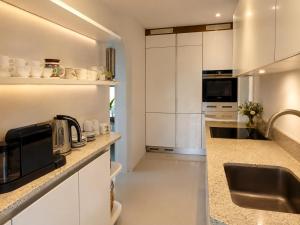 a kitchen with white cabinets and a sink at Casa Panorama in Brissago