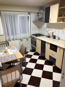 a kitchen with a black and white checkered floor at Transfăgărașean Gateway in Curtea de Argeş