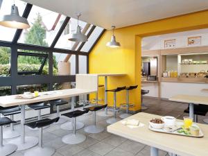 a kitchen with yellow walls and tables and chairs at hotelF1 Limoges in Limoges +19 photos