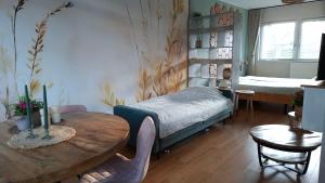 a bedroom with a table and a bed and a table and chairs at Sfeervolle Studio 't kapucijntje Ossendrecht, near Antwerp in Ossendrecht