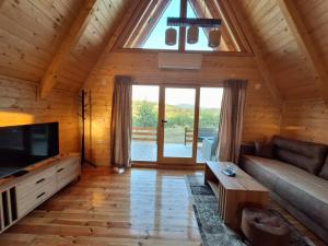 a living room with a couch and a large window at Brvnara kao na dlanu 2 in Rudnik