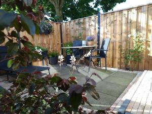 a patio with a table and chairs and a fence at Sfeervolle Studio 't kapucijntje Ossendrecht, near Antwerp in Ossendrecht