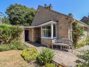 a brick house with a bench in the yard at Woodstock in Chard