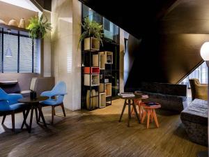a living room with tables and chairs and a couch at Grand Mercure Brasilia Eixo Monumental in Brasília