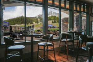 a restaurant with tables and chairs and a large window at Summit Hotel at Big Sky Resort in Big Sky