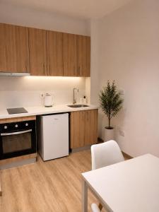 a kitchen with wooden cabinets and a white refrigerator at Valentino By ERMASS ex Valentinos Apts in Paphos