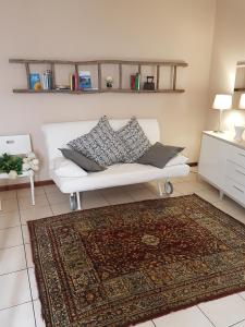 sala de estar con sofá blanco y alfombra en Appartamento al Battistero, en Oggiono