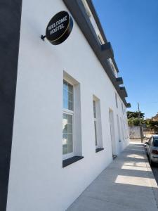 a white building with a sign on the side of it at Welcome Hostel in Churriana