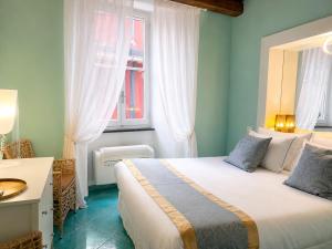 a bedroom with a bed and a desk and a window at La Polena Camere Vernazza - Suite vista mare in Vernazza