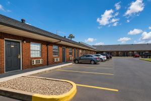 a parking lot with cars parked in front of a building at Stay Inn Checotah near Eufaula Lake in Checotah