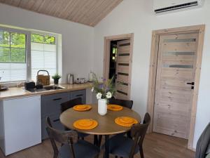 a kitchen with a table and chairs and a kitchen with a sink at Žalčio guolis in Lekėčiai
