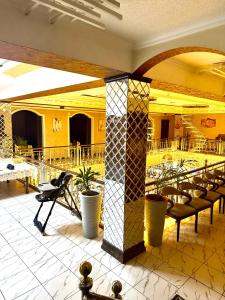 a lobby with chairs and tables in a building at Версаль отель in Türkistan