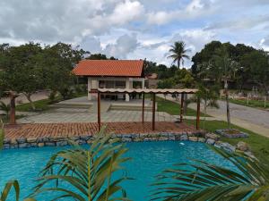 a house with a swimming pool in front of a house at Chalés Sítio Frade in Martins