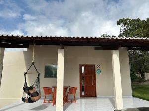 a porch with a hammock hanging from a house at Chalés Sítio Frade in Martins