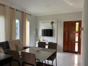 a white living room with a table and chairs at Chalés Sítio Frade in Martins