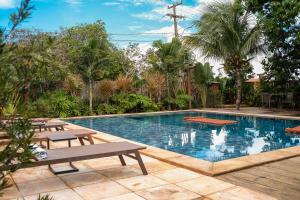 a swimming pool with two tables and two chairs next to it at Hotel Pousada Rancho das Dunas in Santo Amaro
