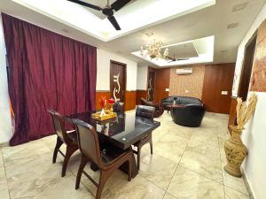 a dining room with a table and chairs and a couch at Moonlight Stays in Gurgaon