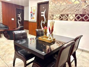 a dining room with a black table and chairs at Moonlight Stays in Gurgaon +17 photos